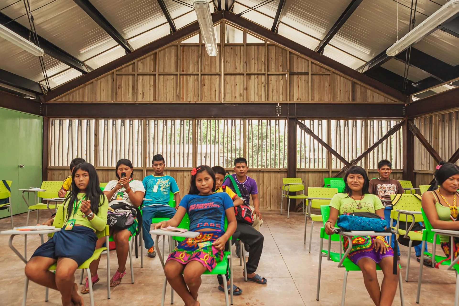 Vista interna de salón de clase abierto con persianas de madera en Colegio Emberá.